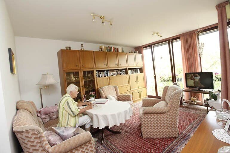 Boewohnerin des Betreuten Wohnens in ihrem Wohnzimmer