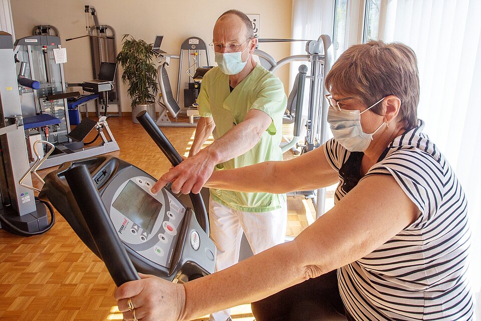 Training in der Corona-Krise mit Mundschutz auf dem Ergrometer