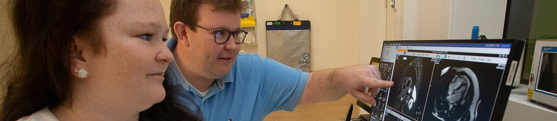 Zwei Radiologie-Fachkräfte betrachten CT-Aufnahmen am Monitor