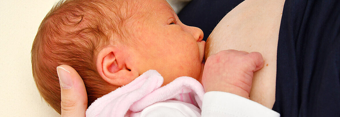 Baby wird an Brust gestillt