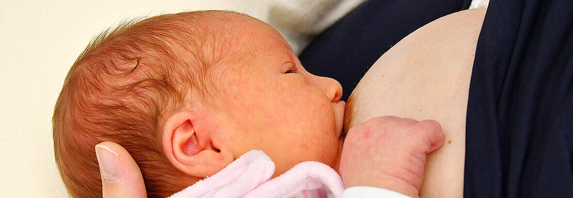 Baby wird an Brust gestillt