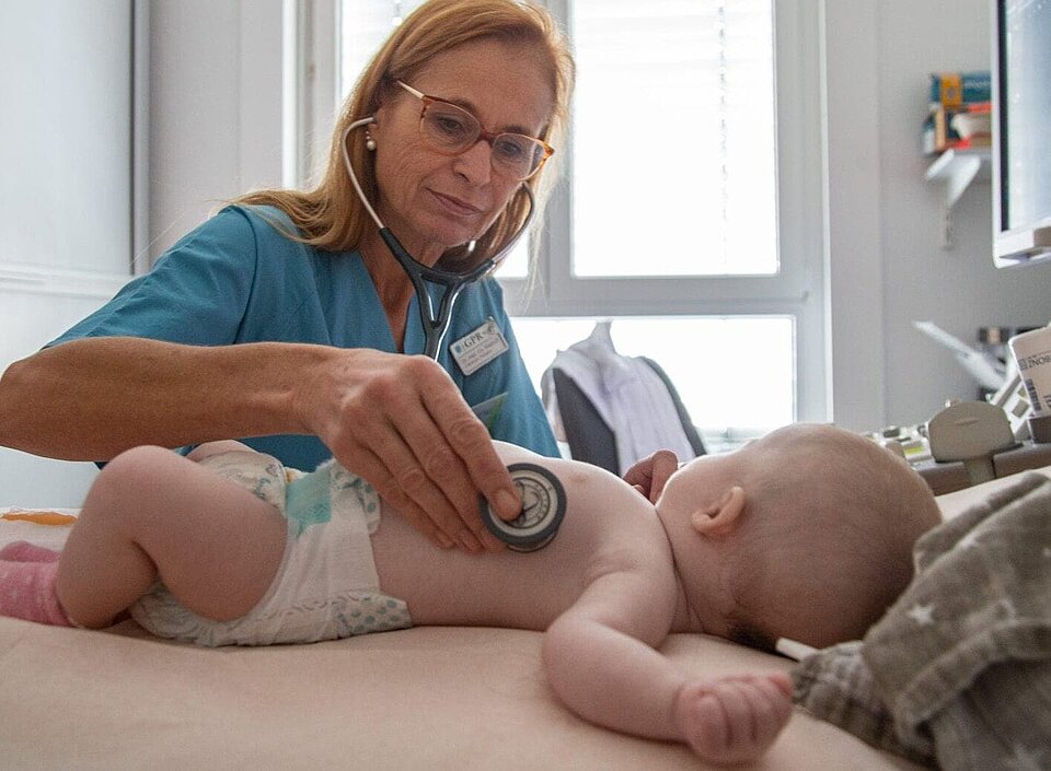 Chefärztin Dr. Christiande Wiethoff untersucht ein Baby mittels Stethoskop