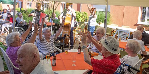 Besucher des Sommerfestes sitzen an einem Tisch