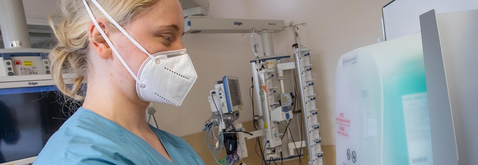 Ärztin am Desinfektionsmittelspender