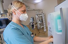 Ärztin am Desinfektionsmittelspender