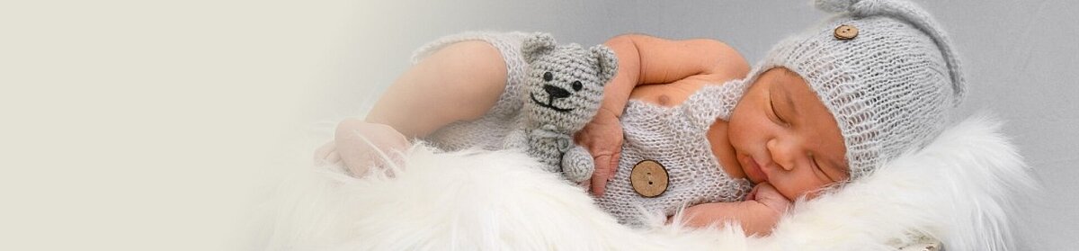 Baby mit Kuscheltier im Arm