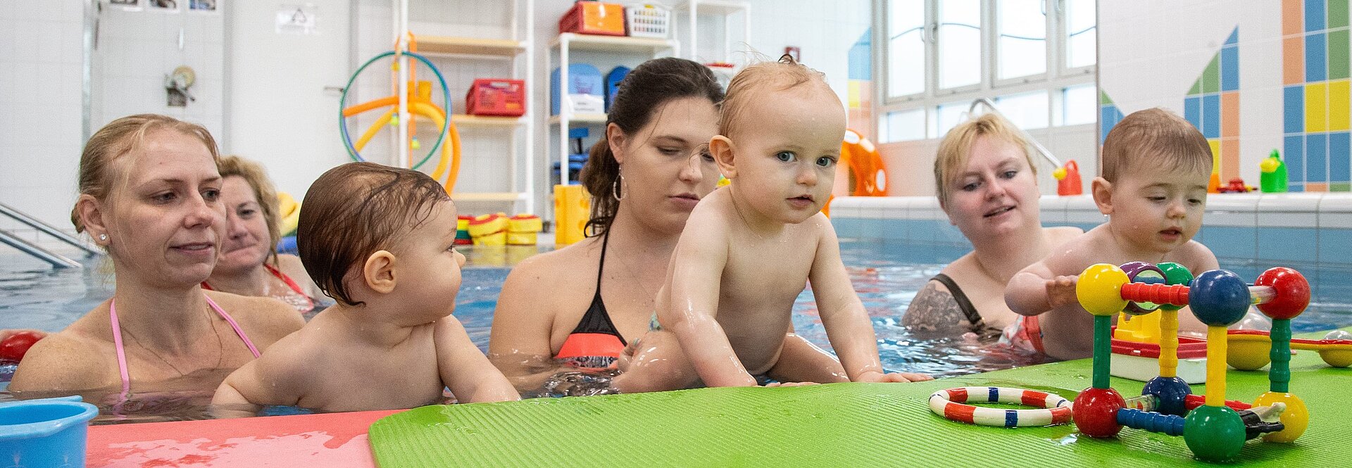 Babyschwimmen: Mütter mit Kindern im Wasser